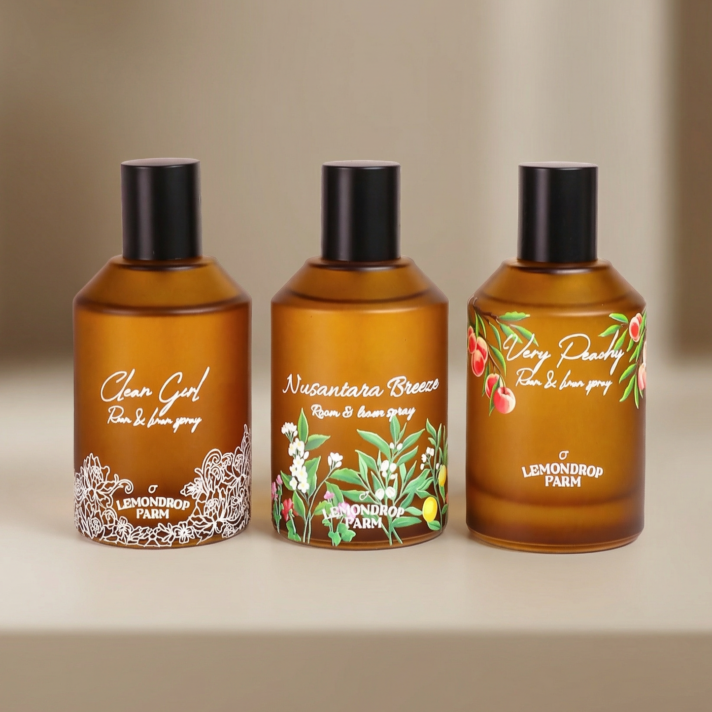 Three beautiful bottles of Lemondrop Farm room and linen sprays on a beige background